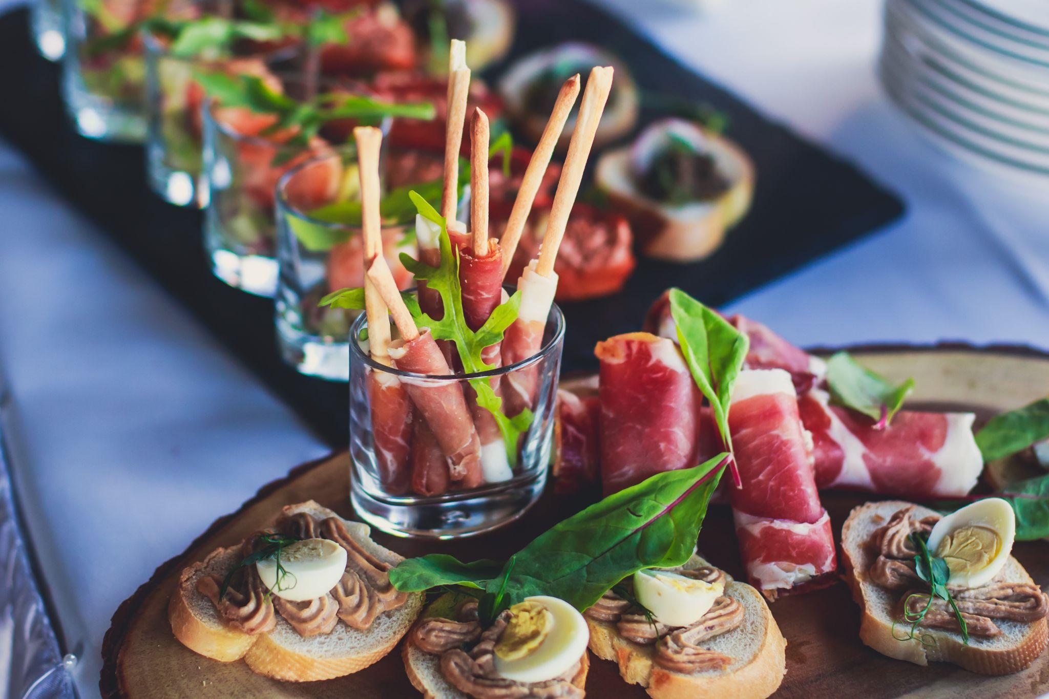 Elegant holiday appetizer display with prosciutto, crostini, and festive garnishes, representing Seattle holiday catering.