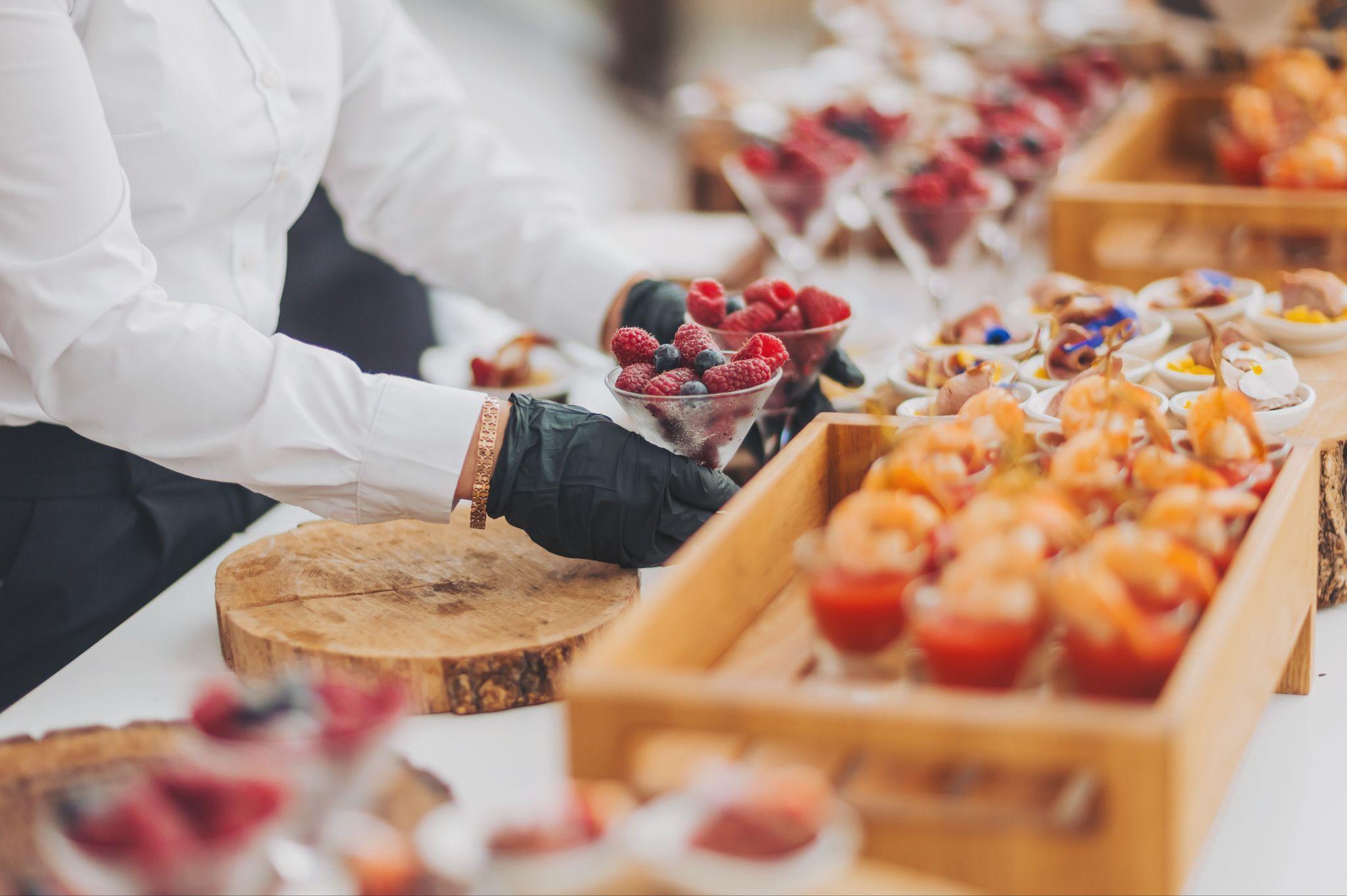 Wedding dessert display featuring berries, mousse cups, and mini pastries