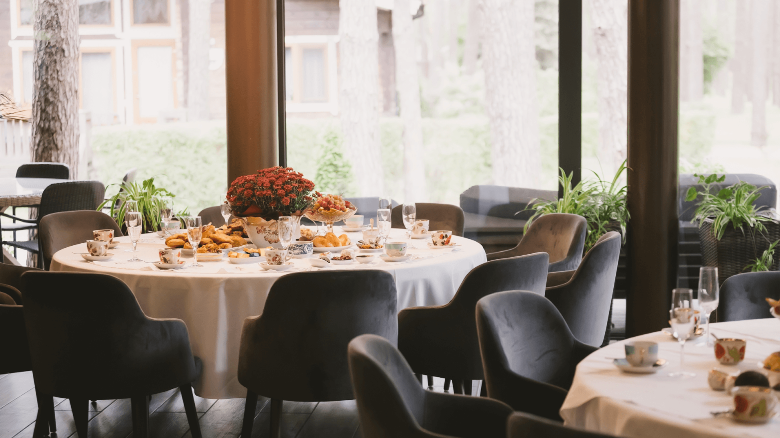 A couple of tables prepared with foods and wine glasses