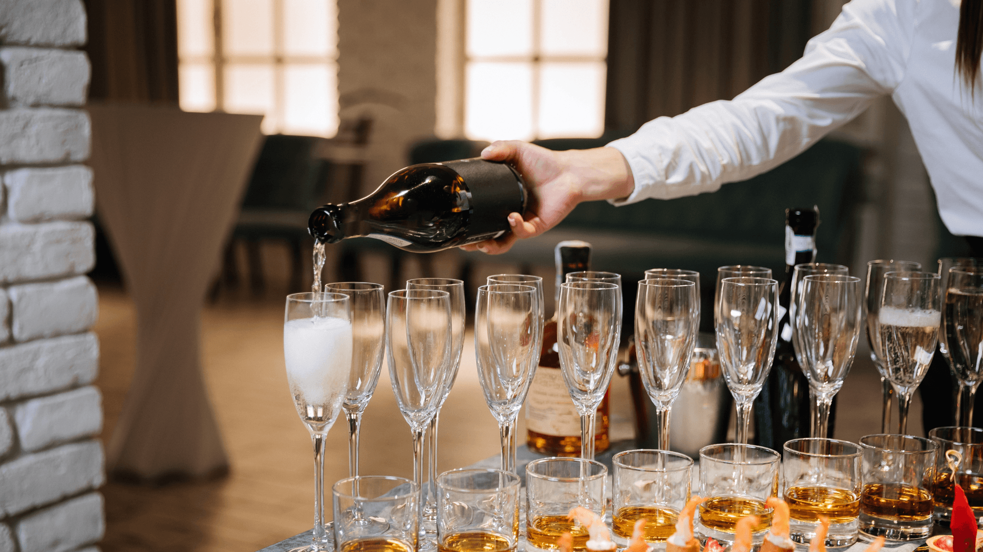 A waiter filling glasses of wine up with wine