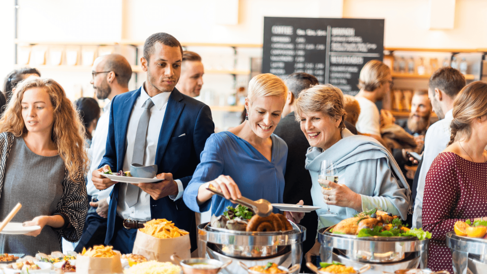People at a catered event grabbing food from the table