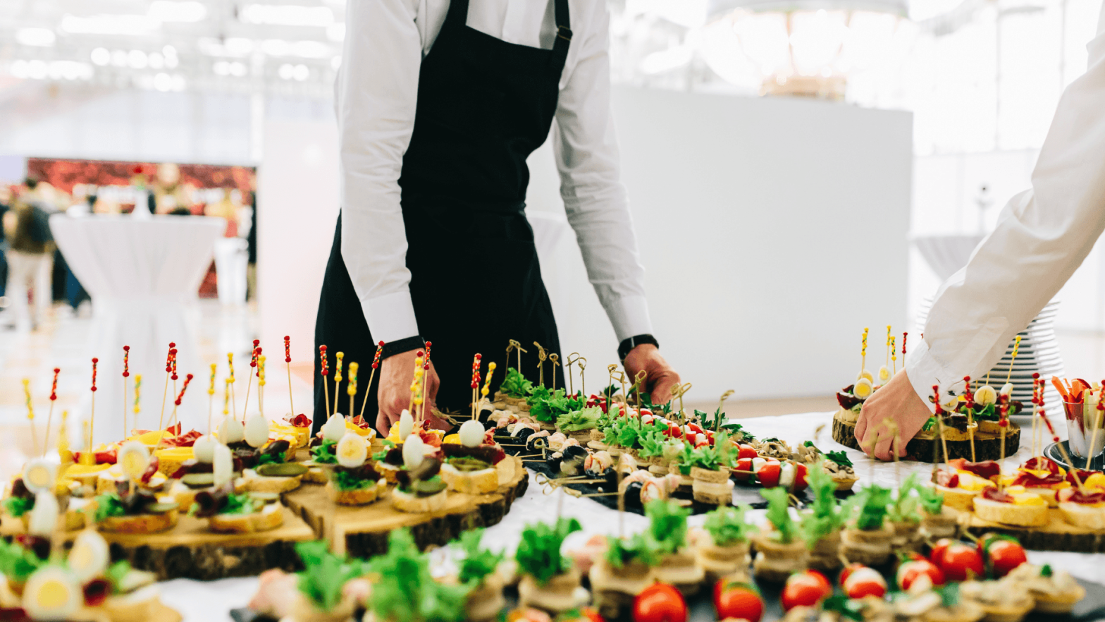 Waiters adding platters of vegetables to a table